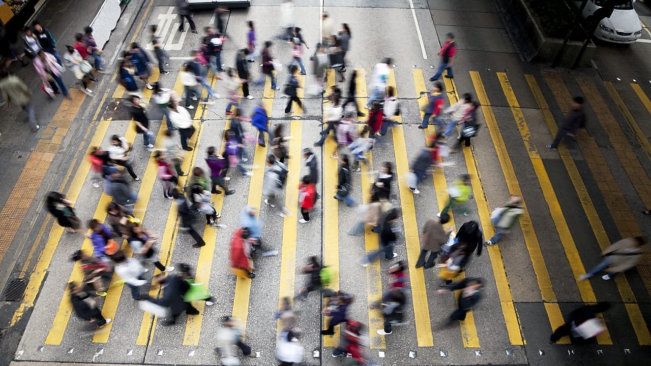 People cross a busy street in Hong Kong