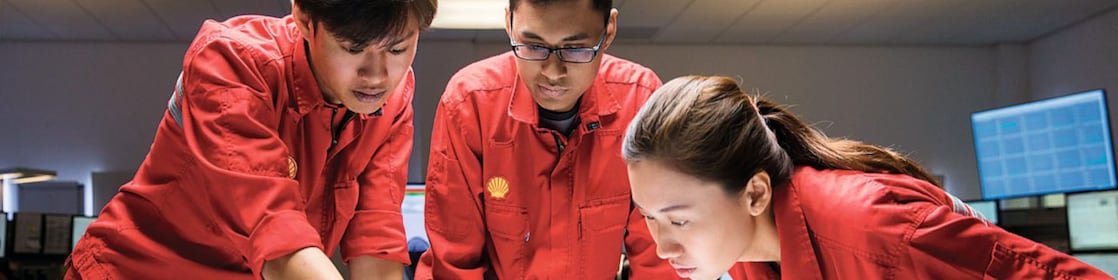 Three employees reviewing plans