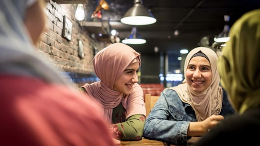 Two women sitting at a table smiling