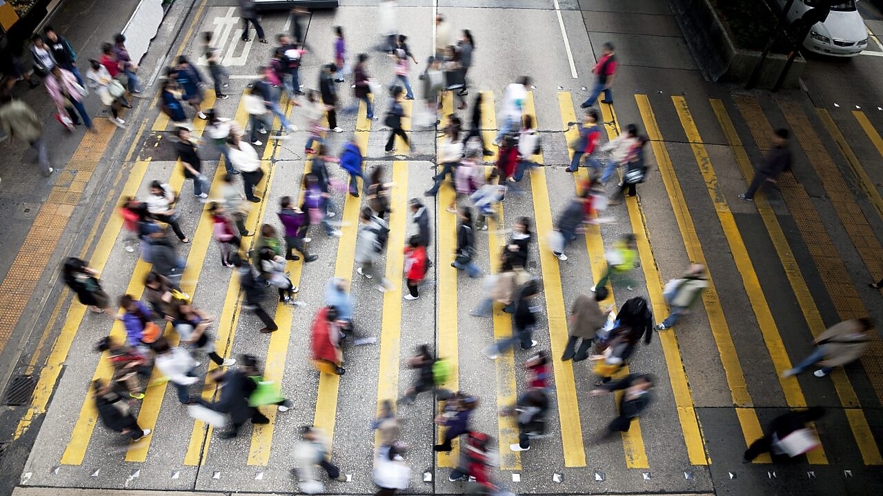 People cross a busy street in Hong Kong