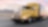 a yellow truck driving down a road at dusk