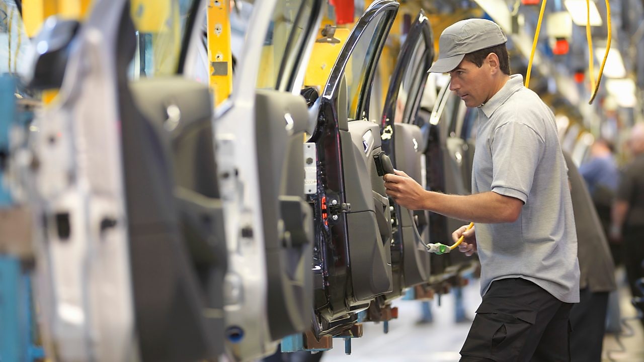 man holding wire looking at machine