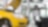 two cars in a garage, one yellow and one white, with their bonnets open, and some car tyres in the background