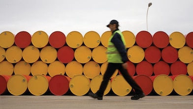 man walking barrels lubricants