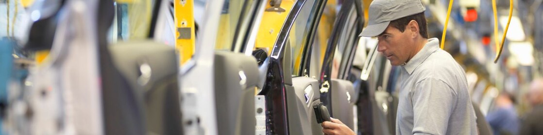 man holding wire looking at machine