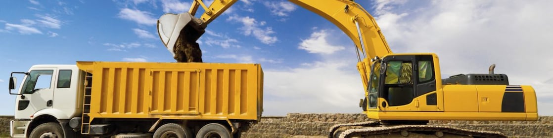 yellow excavator loading mud into a truck