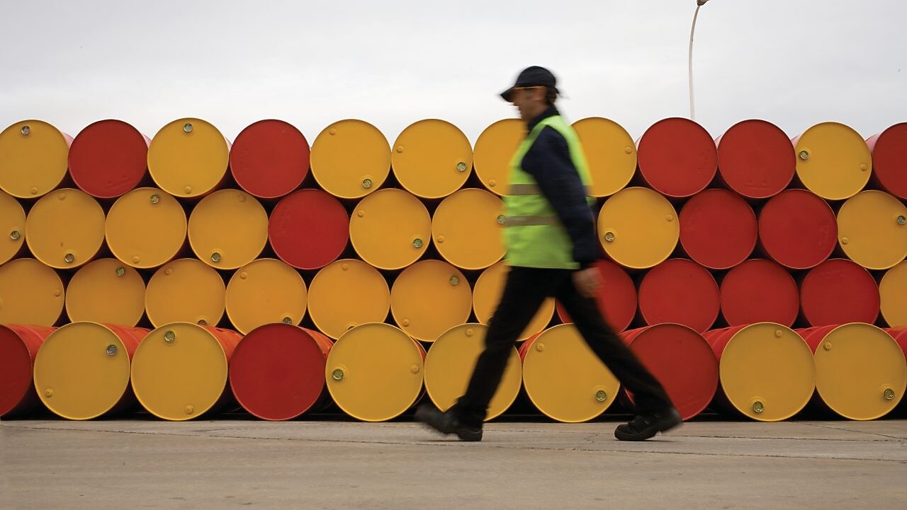 man walking barrels lubricants