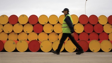 man walking barrels lubricants