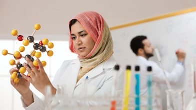 Young female scientist examining a molecular model