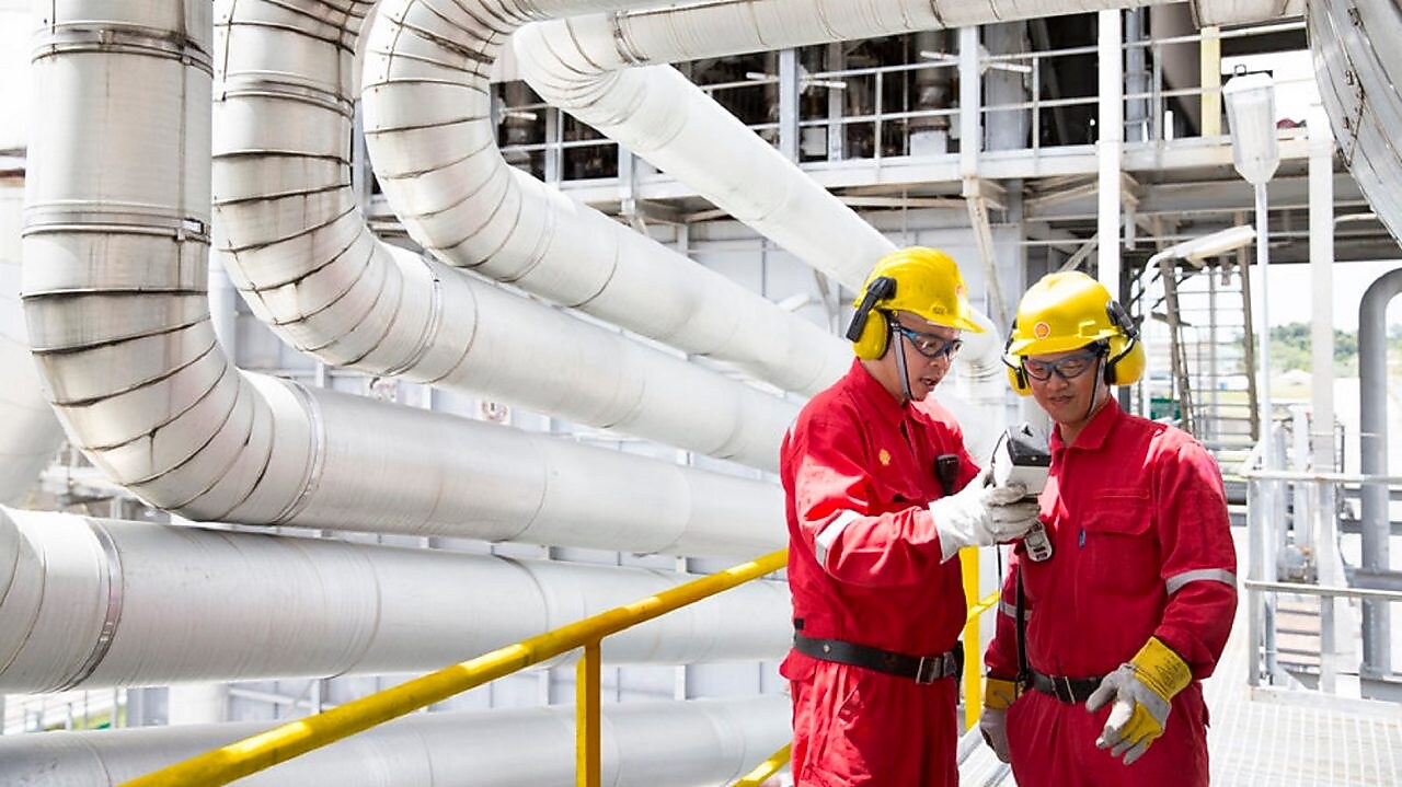 Two engineers looking at equipment in hand