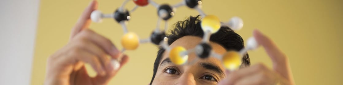 Young man examining molecular model