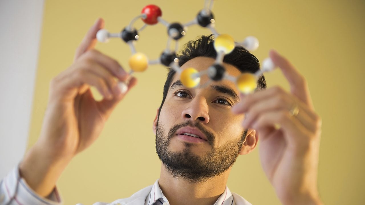 Young man examining molecular model
