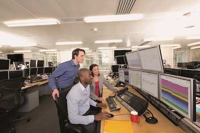 Staff on the Trading Floor examine data on multi computer screens