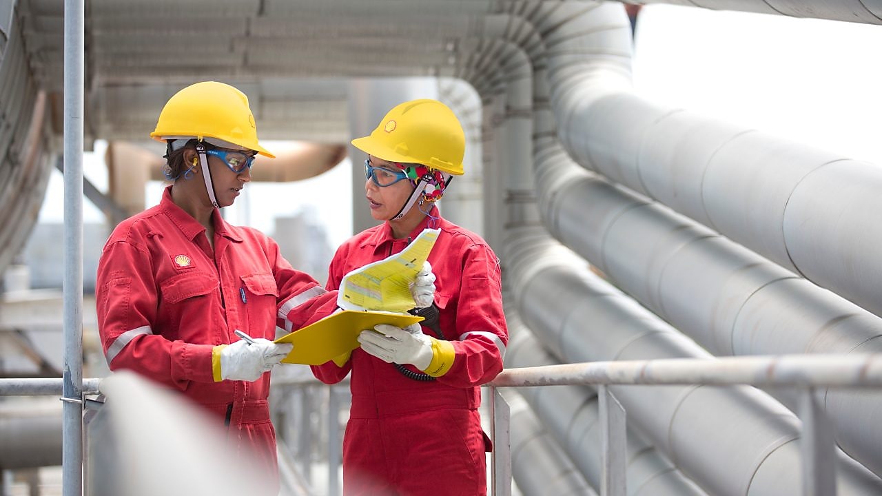 two workers discussing a project in a refinery in Malaysia