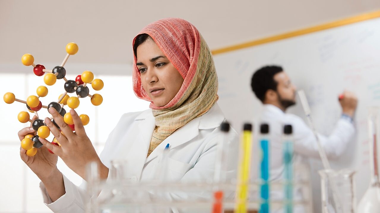 Young female scientist examining a molecular model