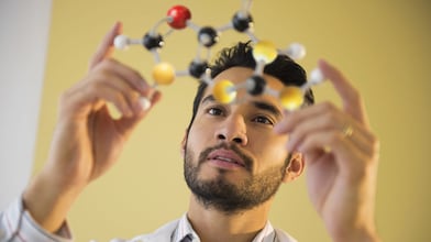Young man examining molecular model