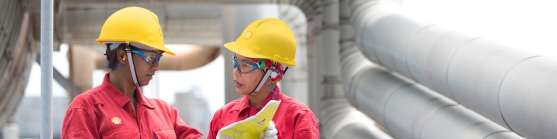 two workers discussing a project in a refinery in Malaysia