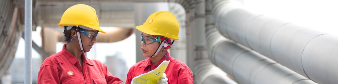 two workers discussing a project in a refinery in Malaysia