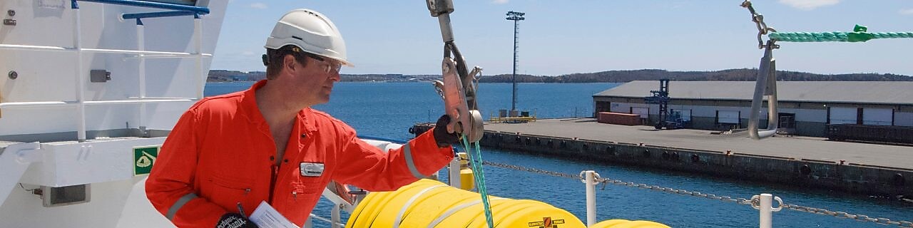 Employee inspectring equipment on a docked boat
