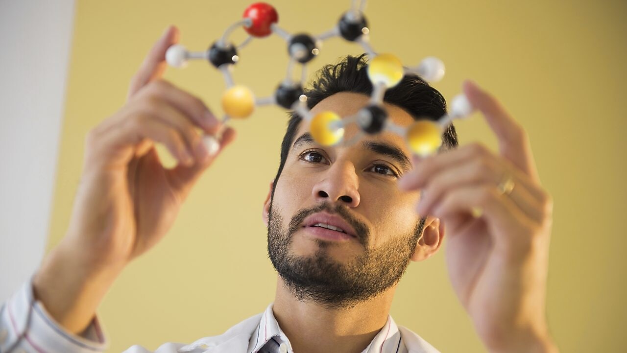 Young man examining molecular model