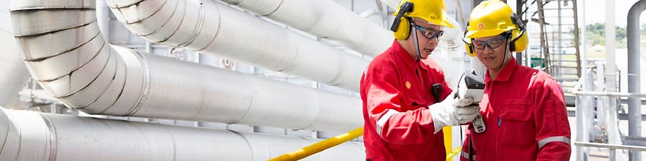 Two engineers looking at equipment in hand