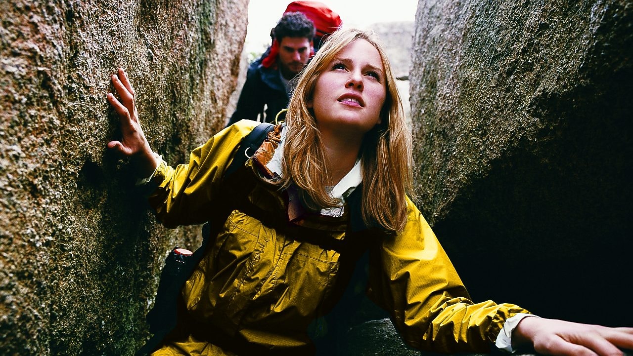 Two young people hiking through a narrow ravine