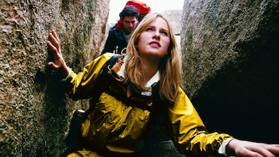Two young people hiking through a narrow ravine