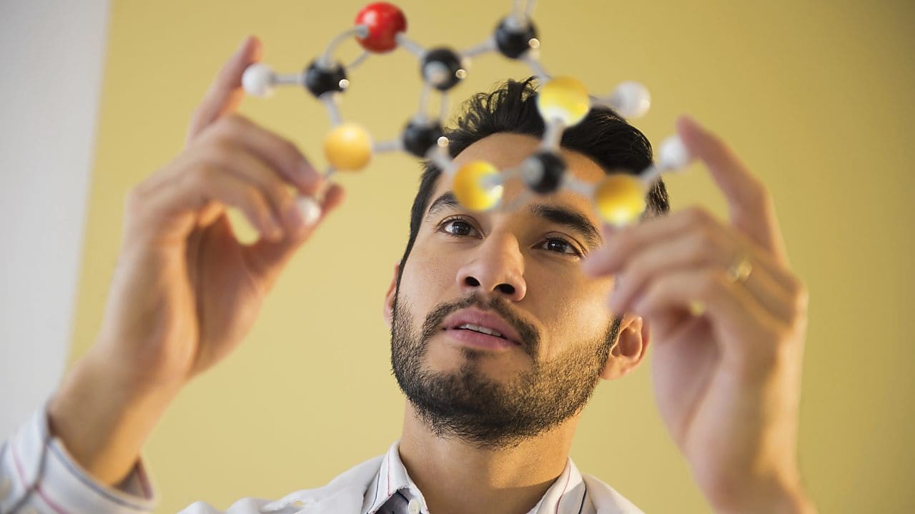 Young man examining molecular model