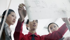 Graduates discussing design plans at work