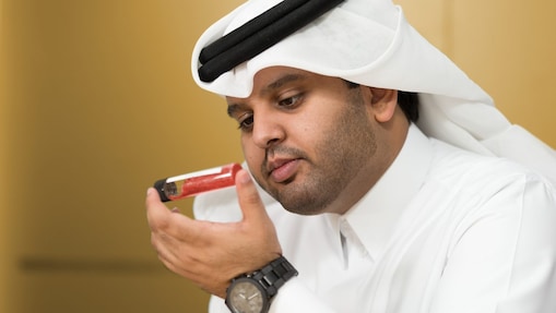 Mohammed Al Athba examines the contents of a capped test tube