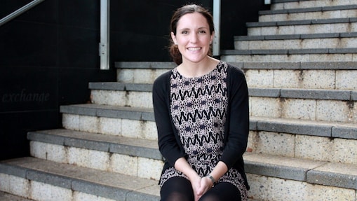 Siobhan Kelly smiles in front of a set of concrete stairs