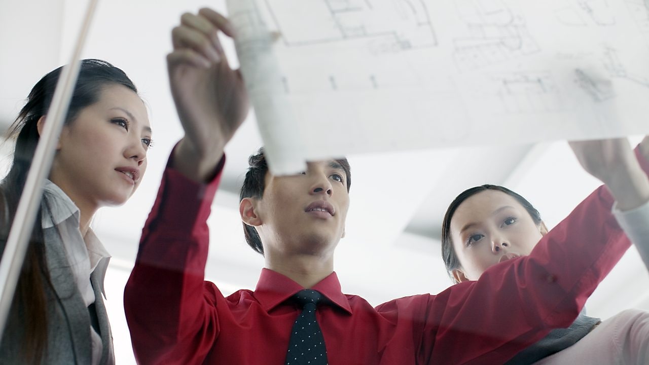 Graduates discussing design plans at work