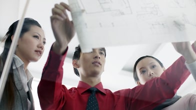 Graduates discussing design plans at work