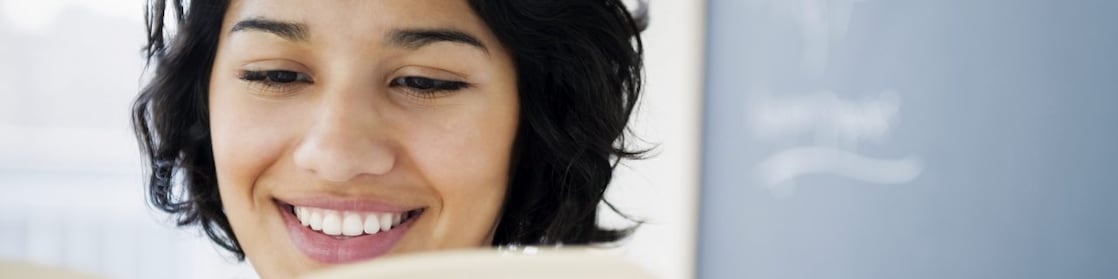 Hispanic woman reading book