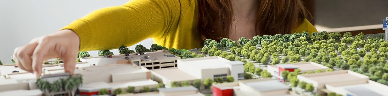 Caucasian businesswoman examining scale model