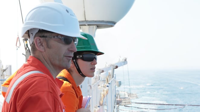 man and woman watching from ship