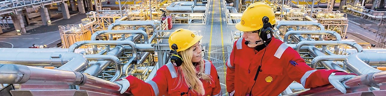 Two shell employees talking at work site