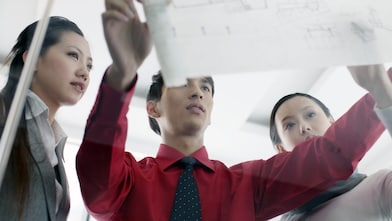 man showing bluprint to colleagues