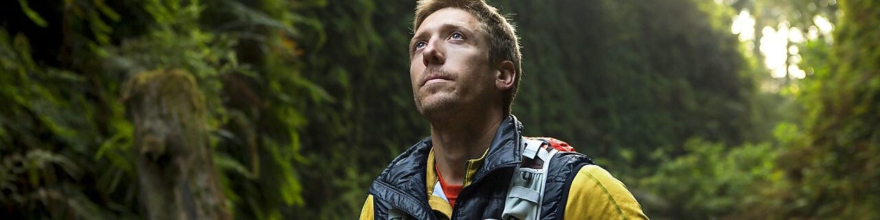 young man hiking through the Redwood forest.