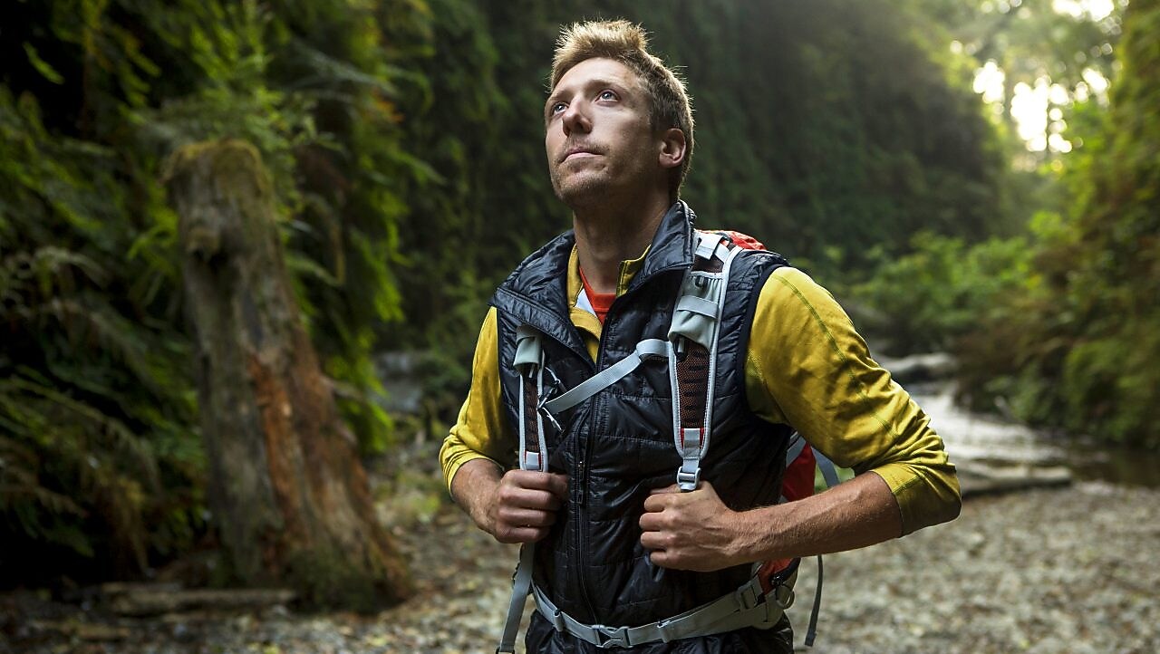 young man hiking through the Redwood forest.