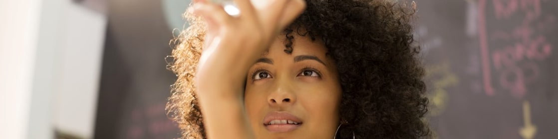 Businesswoman examining crystal ball in office