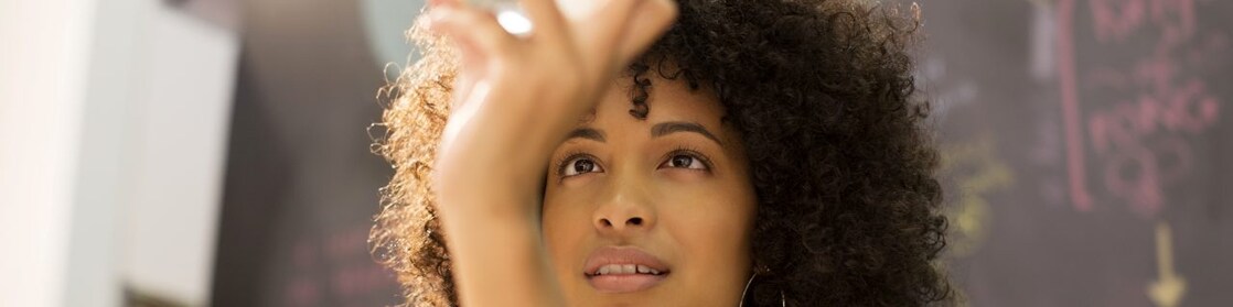 Businesswoman examining crystal ball in office