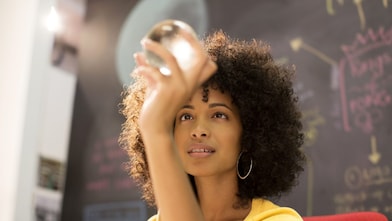 Businesswoman examining crystal ball in office