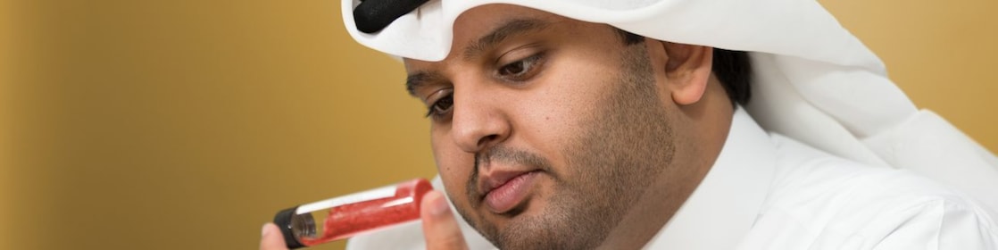 Mohammed Al Athba examines the contents of a capped test tube