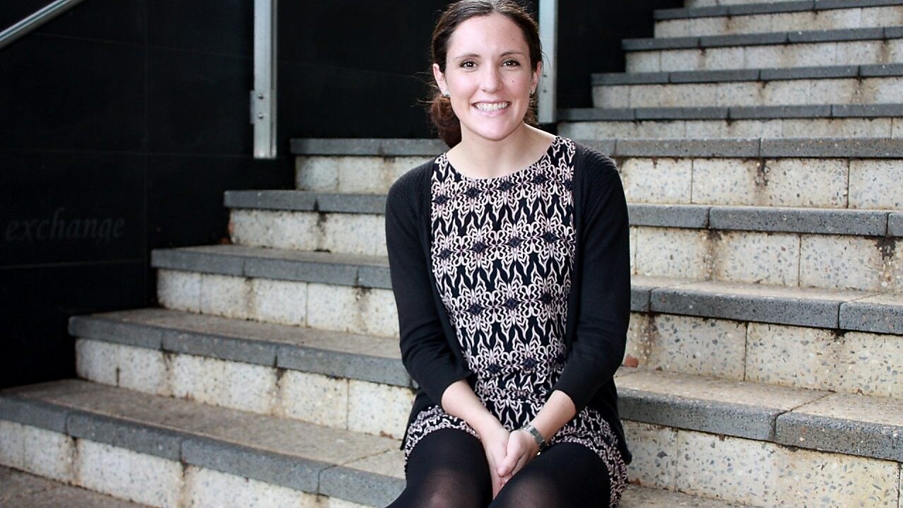 Siobhan Kelly smiles in front of a set of concrete stairs