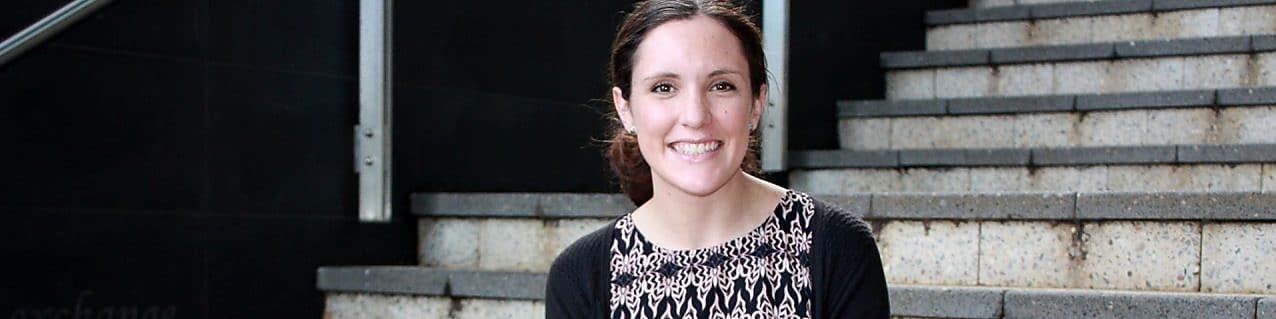 Siobhan Kelly smiles in front of a set of concrete stairs