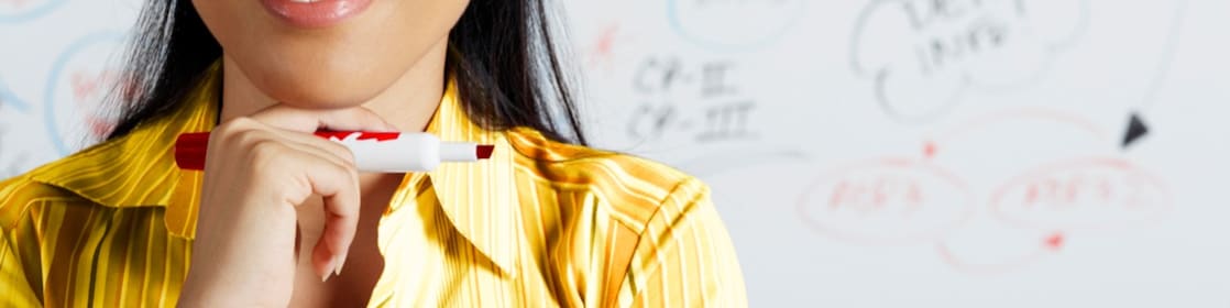 Close up of Asian businesswoman smiling in front of whiteboard