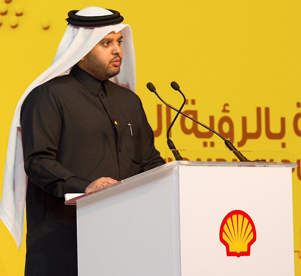 Mohammed Al Athaba stands at a podium giving a speech