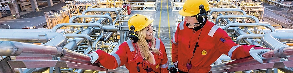 Two shell employees talking at work site