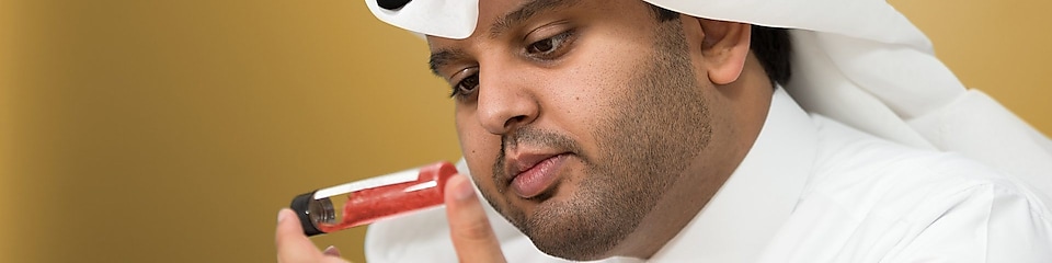 Mohammed Al Athba examines the contents of a capped test tube